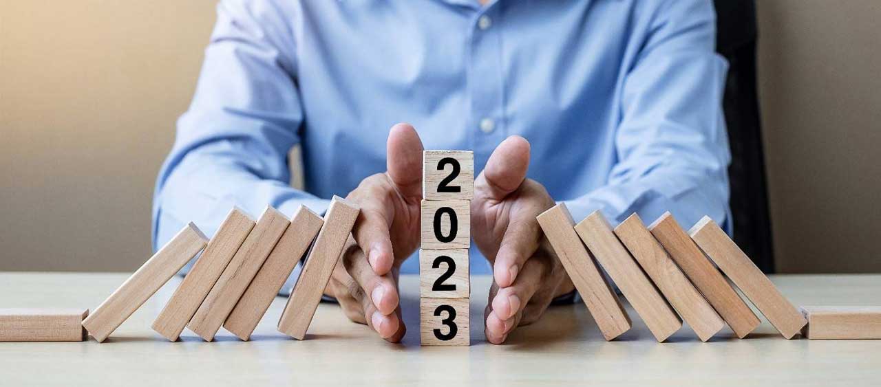 Two hands shielding block letters with the numbers 2023 written on it.  